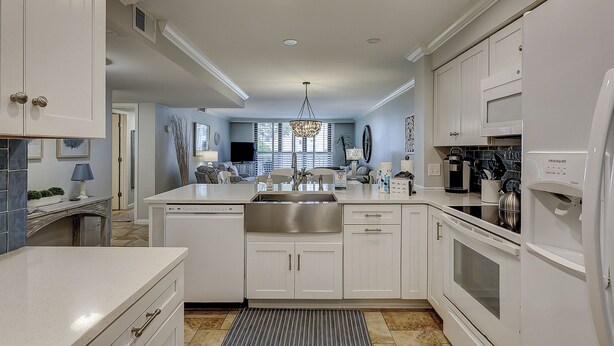 A modern kitchen with white cabinetry, stainless steel appliances, and a central island. - Sunset Rentals | Island Club 6102 (Hilton Head Island)