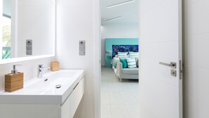 A modern bathroom with a large mirror, white sink, and wooden soap dispenser. - Studio in Las Palmas Near Playa de Las Canteras (Las Palmas de Gran Canaria)