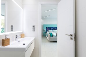 A modern bathroom with a large mirror, white sink, and wooden soap dispenser. - Studio in Las Palmas Near Playa de Las Canteras (Las Palmas de Gran Canaria)