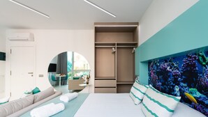 A modern hotel room with a bed, a seating area, a wardrobe, and a large mirror. - Studio in Las Palmas Near Playa de Las Canteras (Las Palmas de Gran Canaria)