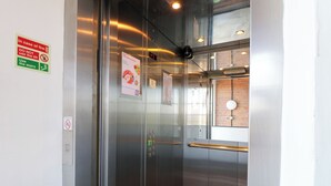 Ein Fahrgastaufzug mit digitalem Display, Notfallanweisungen und Handläufen.