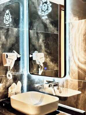 Badkamer | Gratis toiletartikelen, een haardroger, handdoeken, zeep