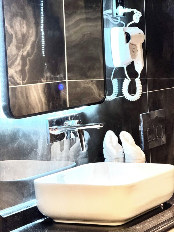 A bathroom with a white sink, a mirror, and a towel rack.