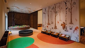 A children's play area with a ball pit, seating, and educational tables.