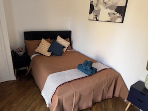 A bedroom with a bed, pillows, a bedside table with a lamp, and a wall art piece. - Spacious Newly Reno 3BR Home with Garden | Sleeps 7 | Near BHX Airport NEC & HS2 (Birmingham)