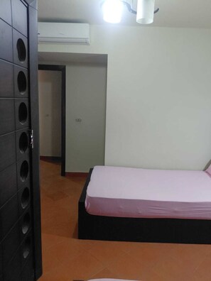 A bedroom with a bed, a wardrobe, and an air conditioning unit. - BeSt PorTo GolF MarIna Chalet (Marsa Matrouh Governorate)