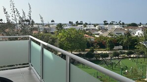 Ein Wohngebiet mit Häusern, einem Spielplatz und freiem Blick auf das Meer.