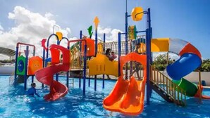 Ein Wasserpark mit Rutschen und Spielgeräten über einem Schwimmbecken.