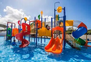 Ein Wasserpark mit Rutschen und Spielgeräten über einem Schwimmbecken.