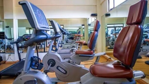 Ein Fitnessstudio mit Trainingsgeräten und Spiegeln.