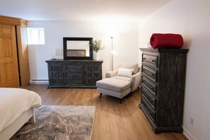 A bedroom with a bed, a dresser, a chair, and a lamp. - Executive Sloan’s Lake Charmer (Denver)