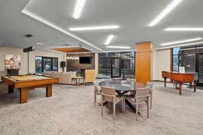 A modern lounge area with a pool table, a round table with chairs, a sofa, and a piano. - Fun Downtown Denver (LoDo) Condo + Free Parking (Denver)