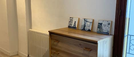 Un mueble de madera con cajones y un radiador debajo.