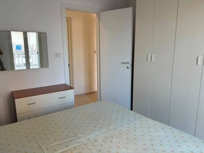 A bedroom with a bed, a dresser, a wardrobe, and a mirror. - Apartment in a Villa, 30 meters from the beach (Agnone)