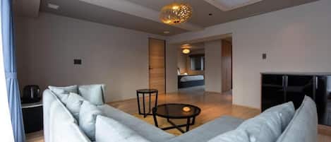 A modern living room with a sectional sofa, a round coffee table, and a fireplace.