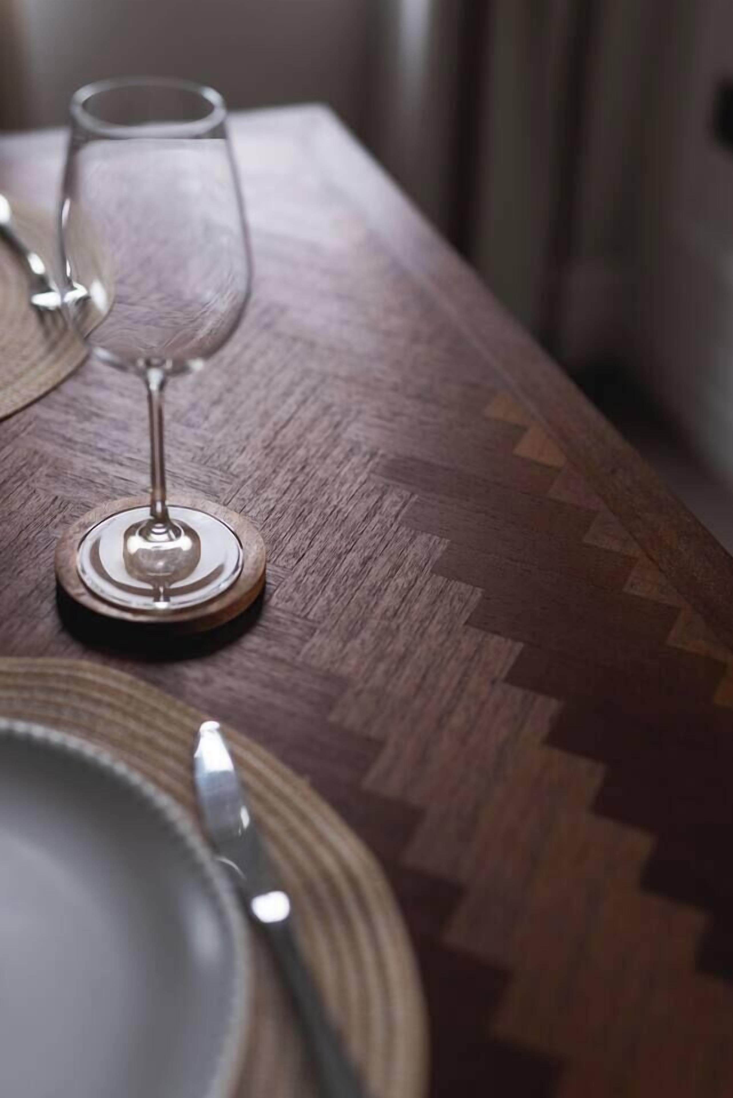 A wooden table with a glass and cutlery.