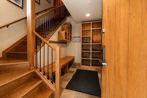 Un escalier en bois avec une rampe métallique menant à un palier.