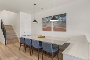 A modern kitchen with a large island, pendant lighting, and artwork on the wall. - Splash And Swing 6 Bedroom Townhouse (St. George)