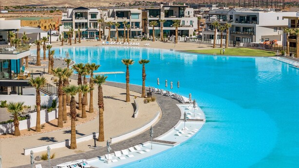 A resort with a large swimming pool, palm trees, and modern buildings. - Splash And Swing 6 Bedroom Townhouse (St. George)