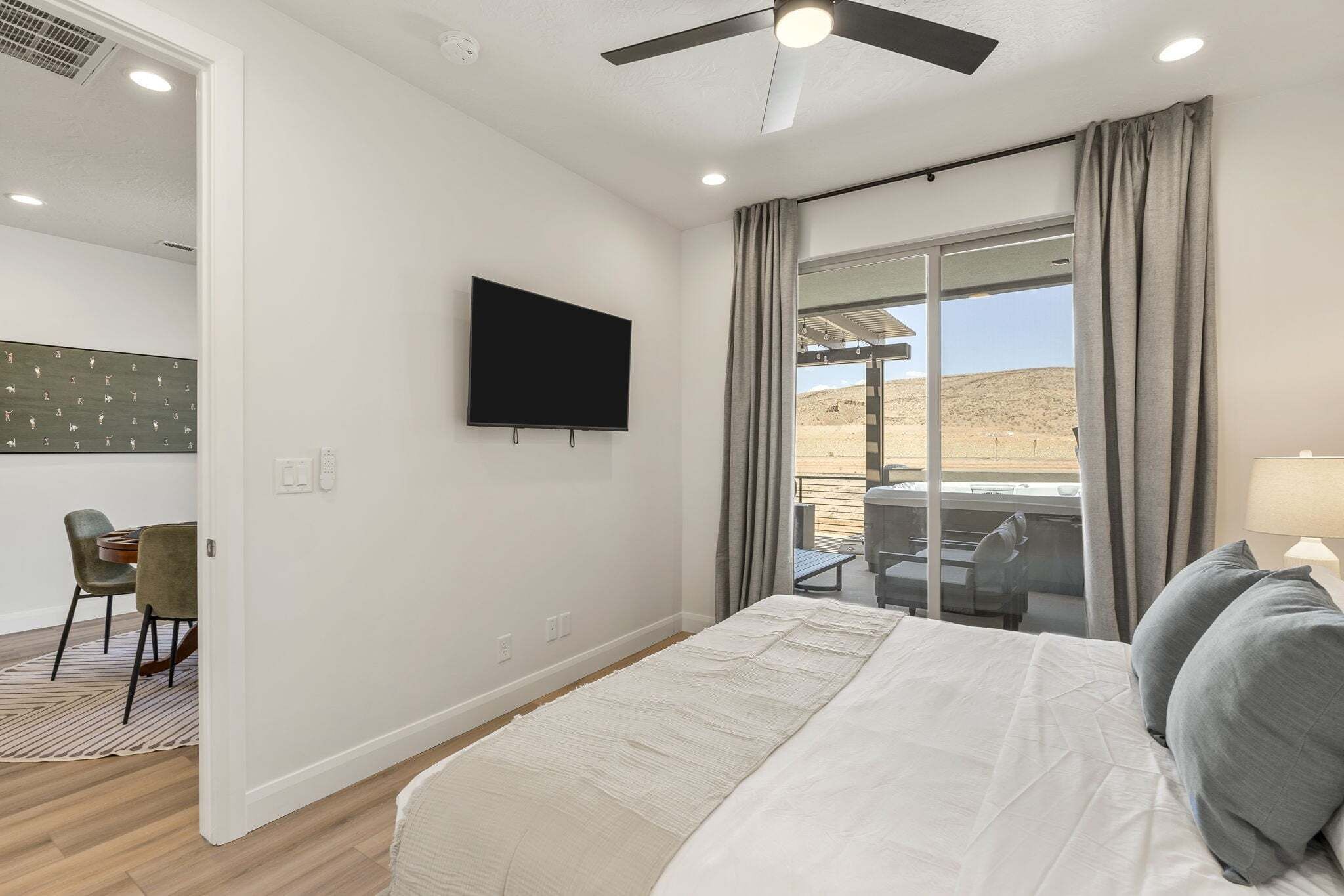 Une chambre d’hôtel avec un lit, une télévision, un bureau avec une chaise et une vue sur le désert.