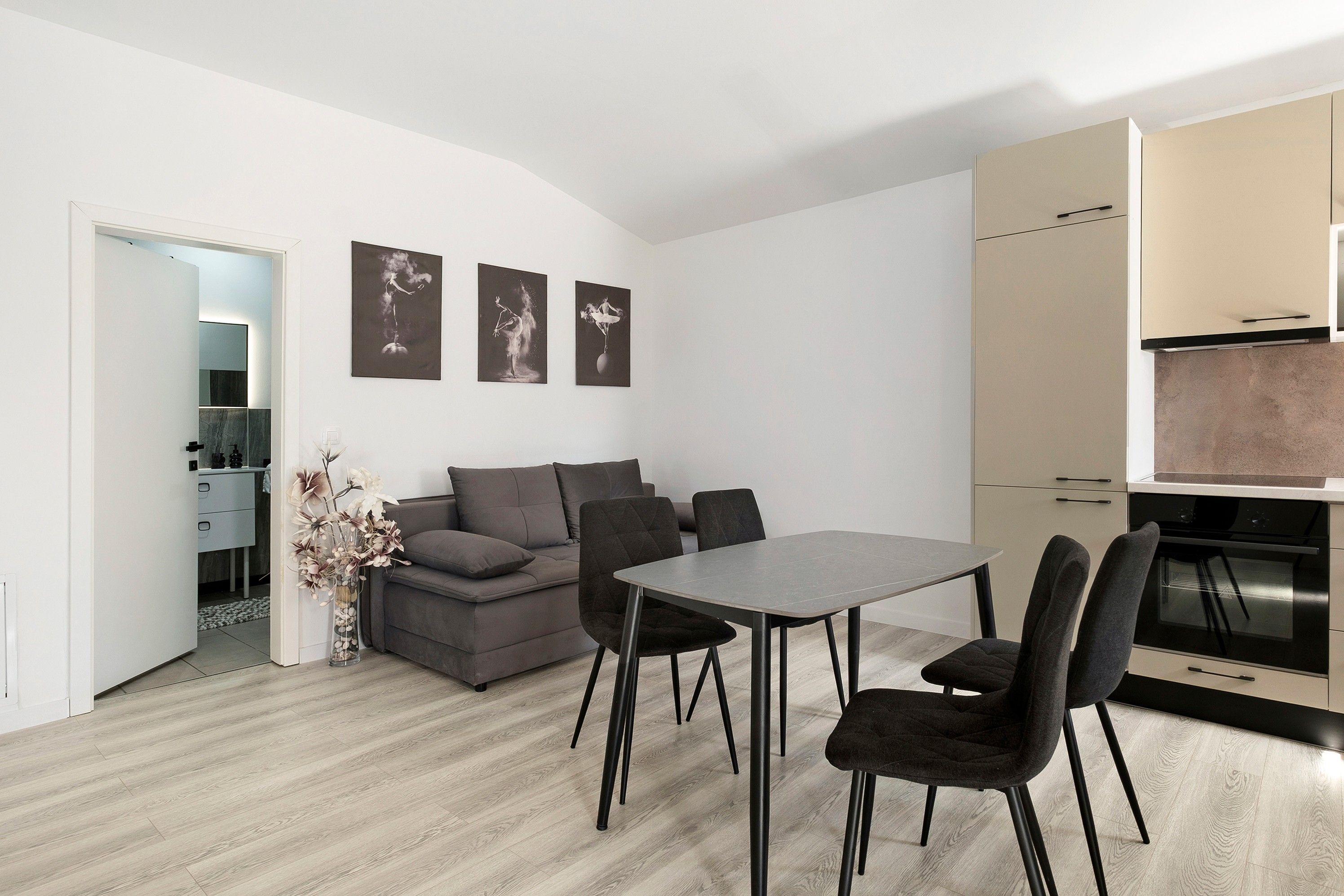 Un espacio de estar moderno con comedor, sofá y una obra de arte en la pared.