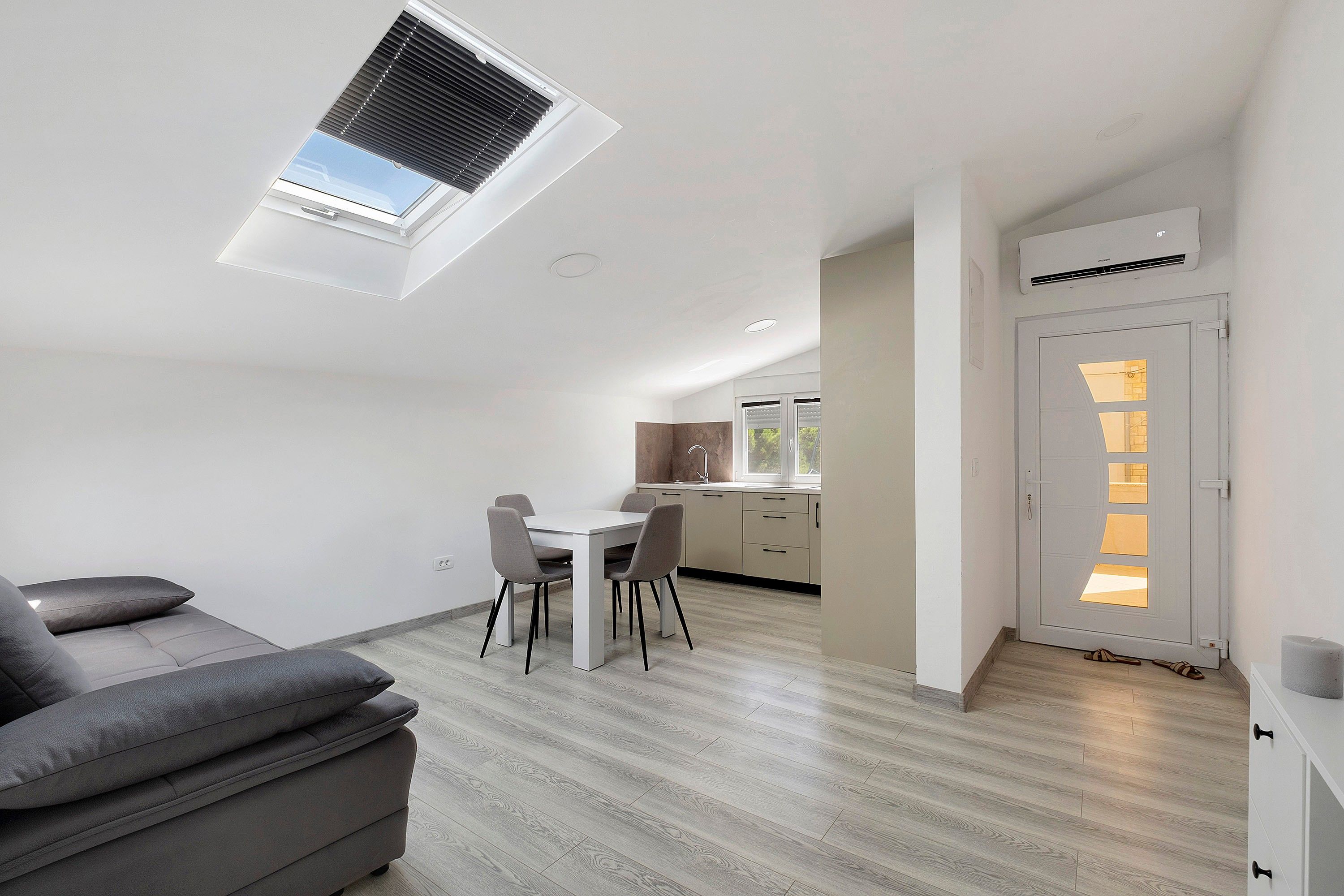 Ein stilvoller Wohnraum mit Essbereich, einer Couch und einer Küche im Hintergrund.