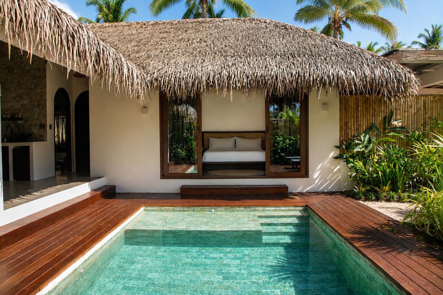 A modern villa with a thatched-roof structure, a private pool, and a bedroom with a view of the pool.