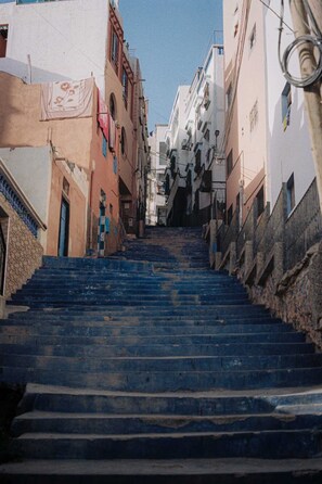 Una calle estrecha con una escalera empinada que sube hacia un edificio.