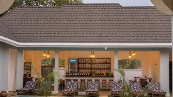 Zona de bar junto a la piscina con asientos y una exhibición de vinos.