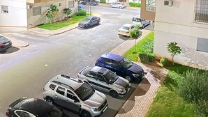 Un edificio residencial de varios pisos con un área de estacionamiento al frente.