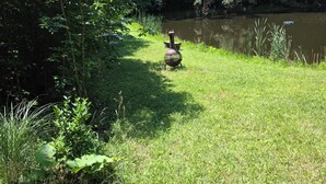 A grassy area with a pond and trees. - Marvelous 2-bedroom cabin (Logan)