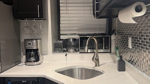 A modern kitchen with a dishwasher, coffee maker, and a microwave. - Discover the Comfort of Columbia University Area-2 (New York)