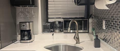 Una cocina moderna equipada con lavavajillas, cafetera y microondas.