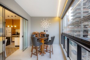 Ein modernes Interieur mit Essbereich, Küche und großen Fenstern mit Blick auf eine Baustelle.