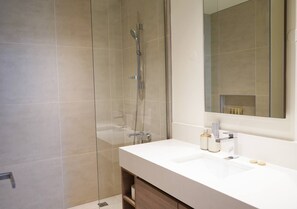 A modern bathroom with a glass shower enclosure, a white sink, and a large mirror. - Spacious 2 bedroom at Creek Edge - All Bills Included for long stay (Dubai)
