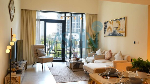 A modern living room with a sofa set, a coffee table, and a dining area with a table set for two. - Spacious 2 bedroom at Creek Edge - All Bills Included for long stay (Dubai)
