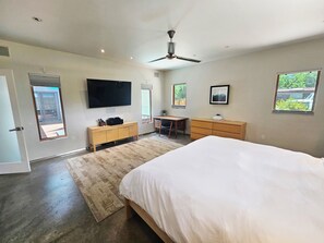 A modern bedroom with a large bed, a desk, a chair, a TV, and a ceiling fan. - Private Luxury Modern Design with NM charm: Gourmet Kitchen & Spa Bath! (Taos)