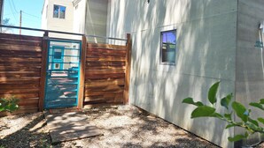 A residential building with a wooden fence, a blue gate, and a small window. - Private Luxury Modern Design with NM charm: Gourmet Kitchen & Spa Bath! (Taos)