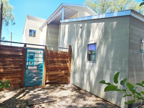 A residential building with a wooden fence, a blue gate, and a small window. - Private Luxury Modern Design with NM charm: Gourmet Kitchen & Spa Bath! (Taos)