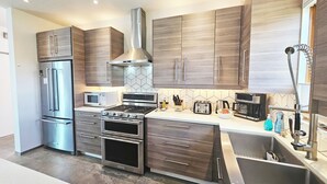 A modern kitchen with stainless steel appliances, wooden cabinets, and a built-in oven. - Private Luxury Modern Design with NM charm: Gourmet Kitchen & Spa Bath! (Taos)