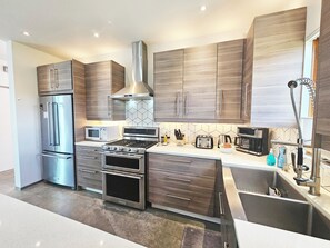 A modern kitchen with stainless steel appliances, wooden cabinets, and a built-in oven. - Private Luxury Modern Design with NM charm: Gourmet Kitchen & Spa Bath! (Taos)