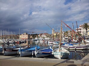 Ein Yachthafen mit verschiedenen Booten, ein Kran im Hintergrund und Gebäude entlang des Ufers.
