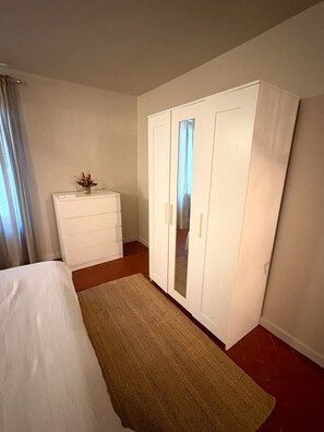 A bedroom with a bed, a dresser, a wardrobe, and a rug. - The Little House — An Air-Conditioned Provençal Retreat (Caumont-sur-Durance)