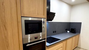Una cocina moderna con armarios de madera, horno empotrado, microondas y estufa.