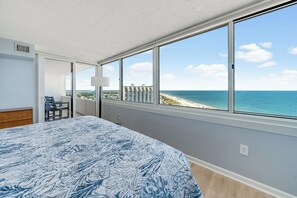 A bedroom with a large window offering a view of the beach and ocean. - Antigua 1103 by Seaside Vacations & Sales (Ocean City)