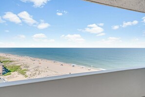 A beach view from a balcony with a clear sky, sandy beach, and ocean. - Antigua 1103 by Seaside Vacations & Sales (Ocean City)