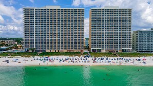 A beachfront hotel with multiple high-rise buildings, a sandy beach, and clear turquoise waters. - Ocean-view escape w/ pools, hot tub & beach access (Panama City Beach)