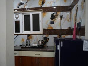 Eine Küche mit Marmorfliesenspiegel, integriertem Mikrowellenherd und Kühlschrank.