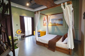 Un dormitorio con cama con dosel, un escritorio con silla y vista a un lago a través de la ventana.