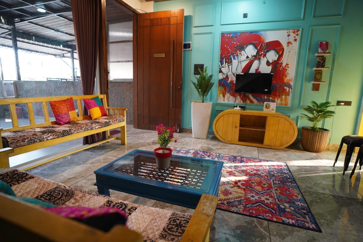A modern living room with a sofa, coffee table, and a colorful rug.